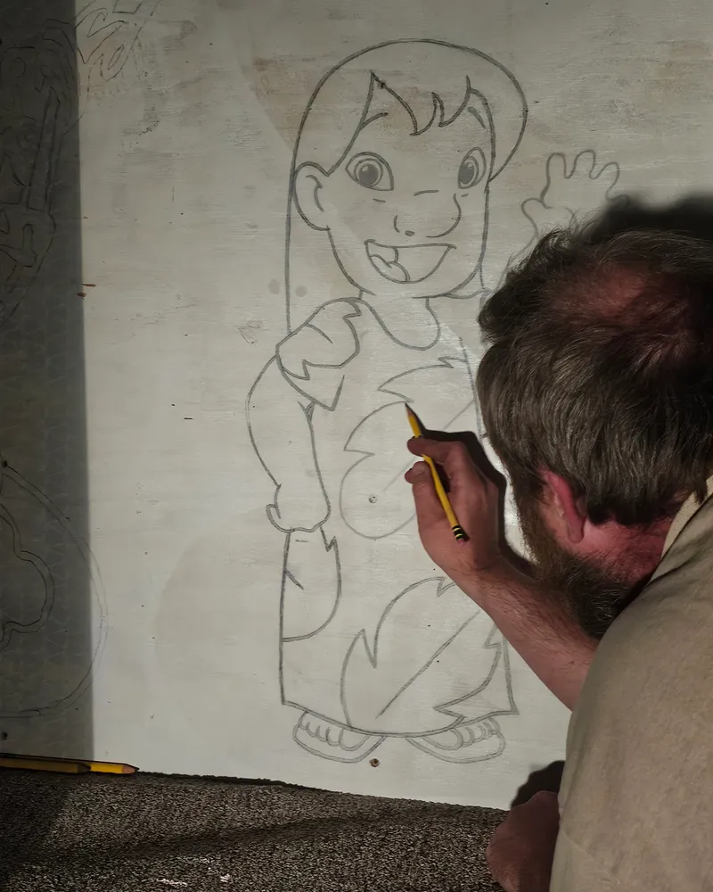 CJ Nikolaus hand-drawing a custom wood cutout